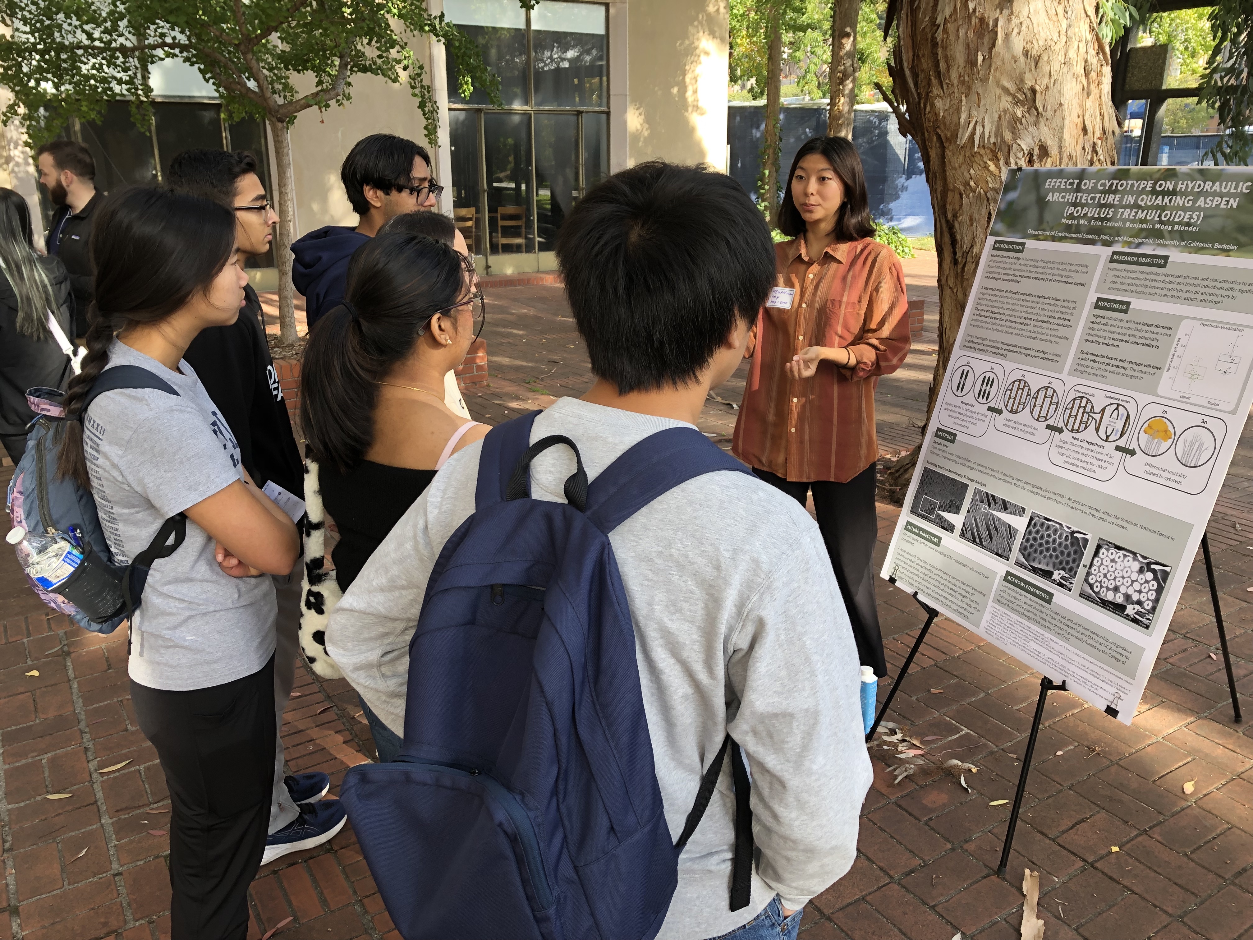 Student explaining a poster to other students